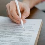 Podpisywanie umowy najmu mieszkania z długopisem w dłoni