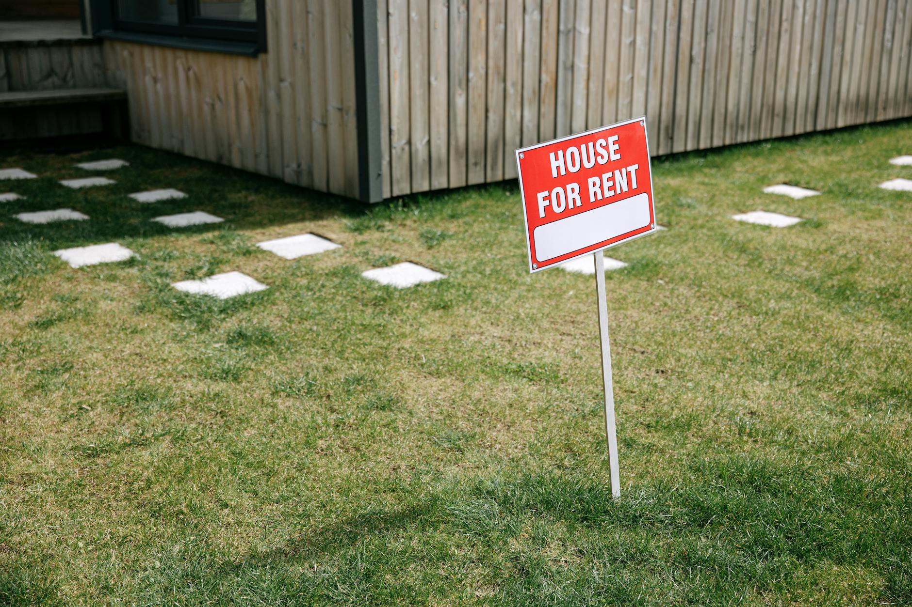 Remont w wynajmowanym lokalu: kiedy ma sens, jak go zaplanować i uzgodnić podział kosztów Tabliczka House for Rent na trawniku przed drewnianym domem